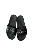 picknpack Hollister black slide sandals with a white script logo on the wide strap and a contoured footbed
