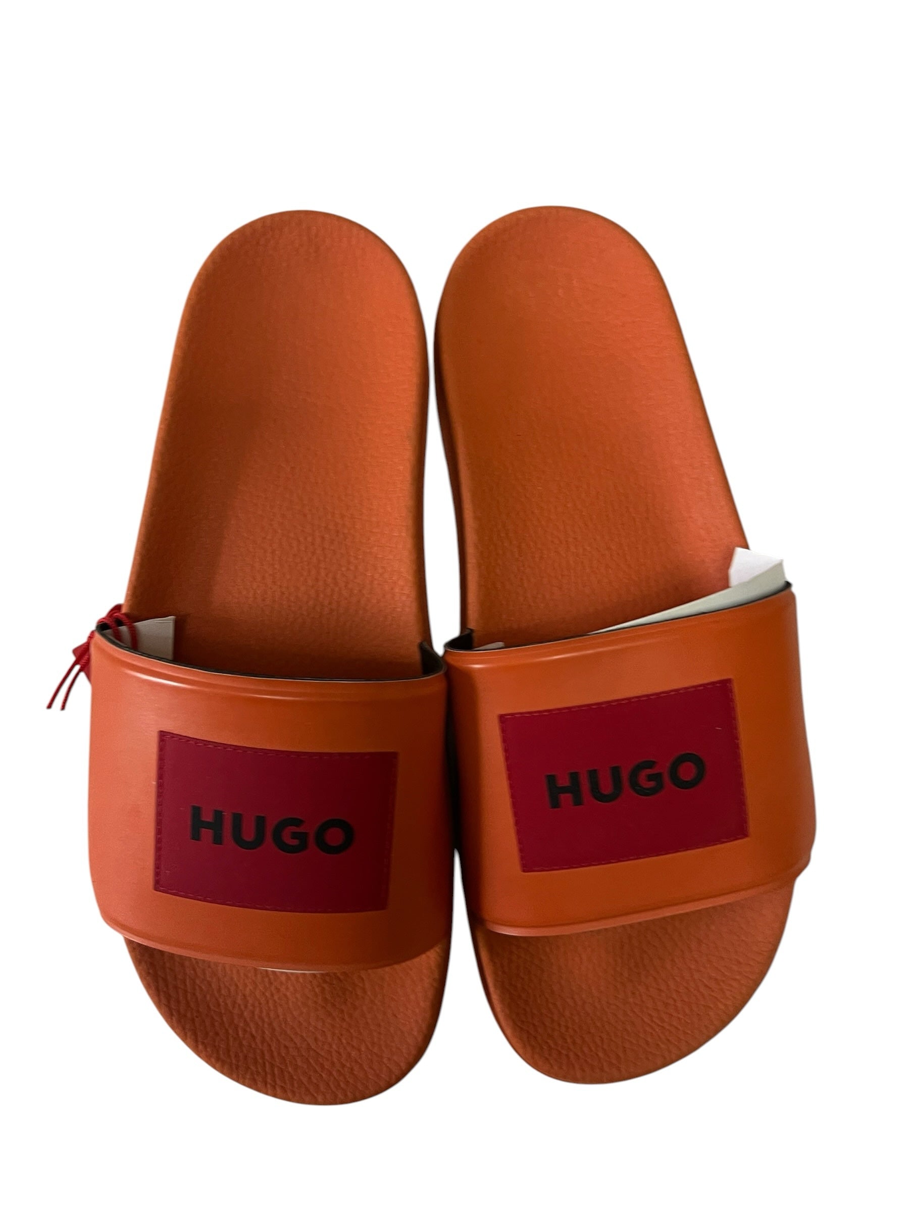 picknpack HUGO orange rubber pool slides with a bold red logo patch on the strap and a contoured footbed